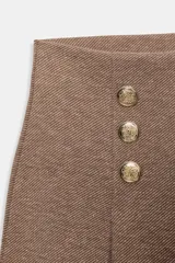 Pantalón de tiro alto con pierna ancha, confeccionado en sarga color tostado. Presenta detalle de doble hilera de botones metálicos dorados en el frente y pinzas verticales.