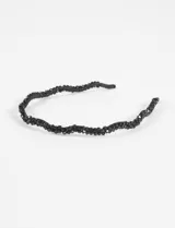 Vincha fina de diseño ondulado, color negro, revestida en su totalidad con abalorios y cuentas facetadas brillantes.