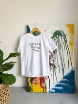 Remera básica blanca de manga corta y cuello redondo, con el texto "Artist In My Free Time" estampado en el frente.