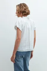 Camisa blanca de manga corta con cuello mao y detalle de punto smock.