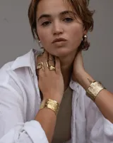 Brazalete rígido de diseño artesanal con textura irregular y acabado metálico, elaborado en bronce macizo.