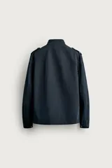 Chaqueta estilo militar relaxed fit de color azul marino, confeccionada en mezcla de algodón y lino. Presenta cuello subido, manga larga con puño abotonado, hombros con trabillas y cuatro bolsillos delanteros de parche con solapa. Se cierra al frente con botonadura metálica dorada.
