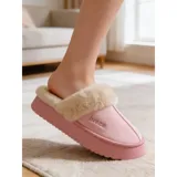 Pantuflas de gamuza negra con plataforma, forradas internamente con corderito sintético color crema. Presentan un diseño sin talón y detalle bordado en el empeine.