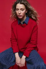 Sweater de tejido de punto negro con tramas de ochos en las mangas y laterales, cuello redondo a la base y mangas largas.