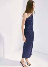Vestido midi asimétrico de un solo hombro, color azul marino, confeccionado en satén con fruncido lateral, tajo discreto en el lateral de la falda y diseño entallado.