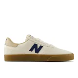 Championes New Balance Numeric 272, color crema con logo lateral en azul marino y suela de goma color caramelo. Confeccionados en una combinación de gamuza y materiales sintéticos, diseñados para ofrecer durabilidad y flexibilidad.