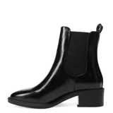 Botas de mujer Miss Carol modelo Lumik, de caña baja, color negro charol, con punta fina y detalle de elástico en los laterales. Taco cuadrado con detalle dorado.