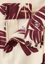 Pantalón de corte regular y tiro medio, con diseño fluido y estampado floral en color bordó sobre fondo beige.