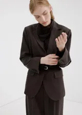 Blazer sastrero de corte recto en color gris oscuro con diseño de rayas diplomáticas, solapas con muesca, bolsillos con solapa en la parte delantera y cierre frontal de un botón.