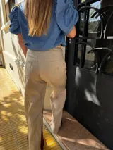 Pantalón sastrero de lino color marrón, de corte recto y tiro alto, con un bordado de caballo en el bolsillo. Presenta costuras en contratono.