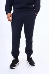 Pantalon de felpa azul marino con cintura elástica ajustable mediante cordón y puños acanalados en los tobillos.