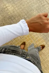 Remera de manga larga color blanco, confeccionada en algodón, con detalle de volados en los puños.