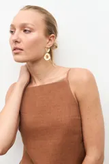 Vestido midi de lino color blanco, de corte recto y holgado, con escote cuadrado y tirantes finos.