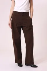 Pantalón de vestir marrón oscuro, de corte recto y holgado, con pinzas frontales y tiro alto.