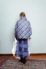 Campera puffer con estampado a cuadros en tonos azul, rojo, amarillo y blanco. Diseño capitoneado a mano y forro interior verde. Corte holgado. Ideal para usar con un look casual.