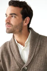 Cardigan marrón tejido con cuello smoking, cierre con botón y bolsillos delanteros.