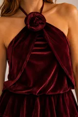 Top de terciopelo color azul marino, con escote halter y detalle de flor desmontable en el cuello.