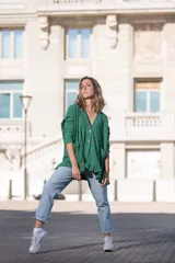 Saco verde esmeralda de tejido morley con botones de madera, corte holgado, escote en V, mangas largas y volados en el ruedo.