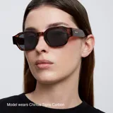 Gafas de sol unisex de forma geométrica, con montura negra y lentes polarizadas negras.