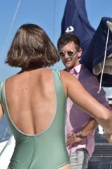 Malla enteriza combinada en colores verde y lila, con escote en V cruzado y detalle de argolla central en la cintura.