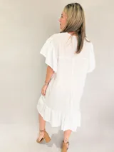 Vestido blanco de corte suelto, con escote en V y mangas cortas con detalles bordados.