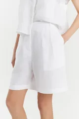 Bermuda blanca de lino de corte recto y estilo sastrero, con bolsillos laterales y cartera de botones oculta.