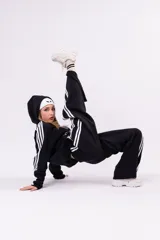 Pantalón deportivo tipo jogger de corte relajado, color negro con franjas laterales blancas y cintura elástica fruncida.
