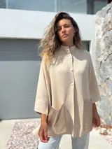 Saco tejido de punto en color crudo, con diseño holgado, mangas tres cuartos y bolsillos frontales grandes confeccionados en cuero metalizado plateado.