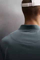 Chaqueta técnica de corte relajado, confeccionada en tejido compacto y elástico. Presenta cuello y puños acabados en rib, cierre frontal con cremallera, bolsillos frontales con cremallera oculta y bajo ajustable con elástico en los laterales.