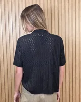 Cardigan calado de manga corta, tejido en punto con cierre frontal de botones y cuello redondo.