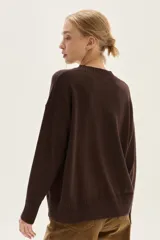 Sweater de tejido de punto color marrón oscuro, con cuello redondo y bordado frontal que incluye texto "Winter Glow" rodeado de motivos florales en tonos azules, rojos y blancos.