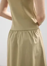 Vestido midi color tostado, con cuerpo superior de punto sin mangas con cuello alto y falda larga de tejido plano con vuelo.