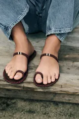 Sandalia plana con tira para el dedo y tira en el empeine con detalle de abalorios. Suela con pespuntes a contraste de color y acabado en punta redonda.