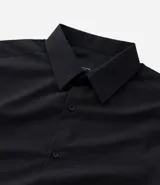 Camisa de corte regular confeccionada en microfibra, con cuello inglés, manga larga y cierre frontal abotonado. Presenta un diseño liso y minimalista, ideal para un estilo formal o de oficina.