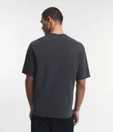 Remera de corte boxy y diseño liso, confeccionada en algodón con efecto desteñido, cuello redondo alto y mangas cortas.