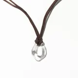 Colgante con cordón marrón de gamuza sintética y dije circular transparente.