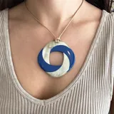 Collar con colgante circular de asta y asta esmaltada en negro y dorado, con cordón negro ajustable.