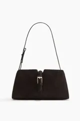 Cartera bandolera de hombro color marrón oscuro, con correa fina ajustable y cierre metálico dorado en la parte delantera. Incluye bolsillo interior con cierre y está forrada.