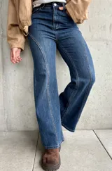 Jean de tiro alto con corte semi oxford, confeccionado en denim con elasticidad. Presenta un diseño con costuras verticales decorativas en el frente que estilizan la silueta.