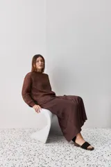 Falda midi color negro al bies, confeccionada en tela de textura suave y caída fluida, de diseño minimalista y silueta recta.