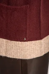 Cardigan abierto de punto con diseño de bloques de color en tonos beige, marrón y bordó. Presenta mangas largas, corte recto y bolsillos frontales aplicados.