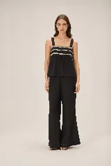 Top de lino color negro con silueta relajada, tirantes anchos y detalles de puntilla bordada en el pecho.