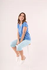 Pijama de dos piezas color coral, compuesto por una remera de manga corta con botones y un pantalón capri estampado con flores.