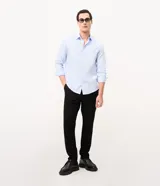 Camisa de corte regular para hombre, en color celeste con finas rayas verticales blancas. Cuenta con cuello camisero tradicional, mangas largas con puños abotonados y cierre frontal con botones.
