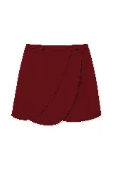 Falda corta tipo wrap de color bordó, con diseño de paneles superpuestos y bordes redondeados.