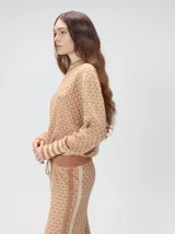 Sweater de tejido de punto jacquard con diseño geométrico, cuello redondo y puños acanalados en contraste de color verde y beige.