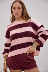 Sweater de tejido de punto con diseño de rayas horizontales anchas en color rosa y bordó, de corte holgado, cuello redondo y mangas largas.