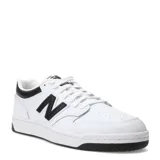 Championes New Balance modelo 480, de diseño inspirado en el básquetbol de los años 80. Presentan una capellada de cuero blanco con detalles en negro, incluyendo el logo lateral, el talón y la suela. Cuentan con cierre de cordones y perforaciones en la puntera para mayor ventilación.