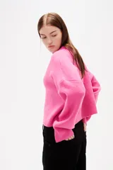 Sweater de tejido de punto color negro, con cuello redondo a la base, mangas largas y diseño holgado.