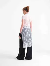 Vestido largo de encaje blanco con diseño de inspiración japonesa, cuello alto, abertura frontal y mangas cortas.